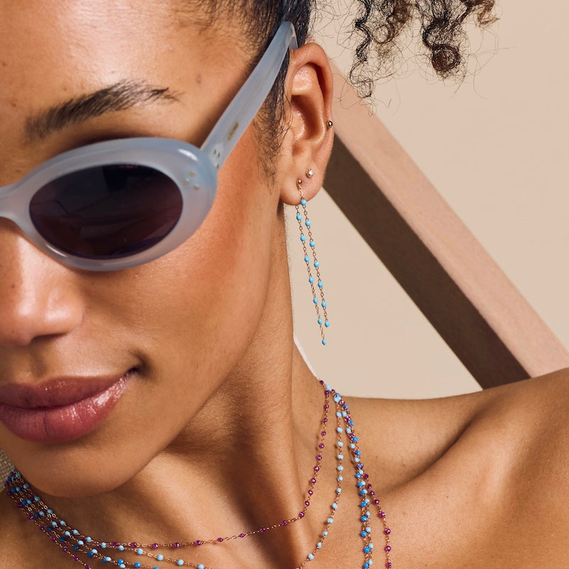 Photo d'une femme portant des boucles d'oreilles dansantes de couleur turquoise Gigi Clozeau.