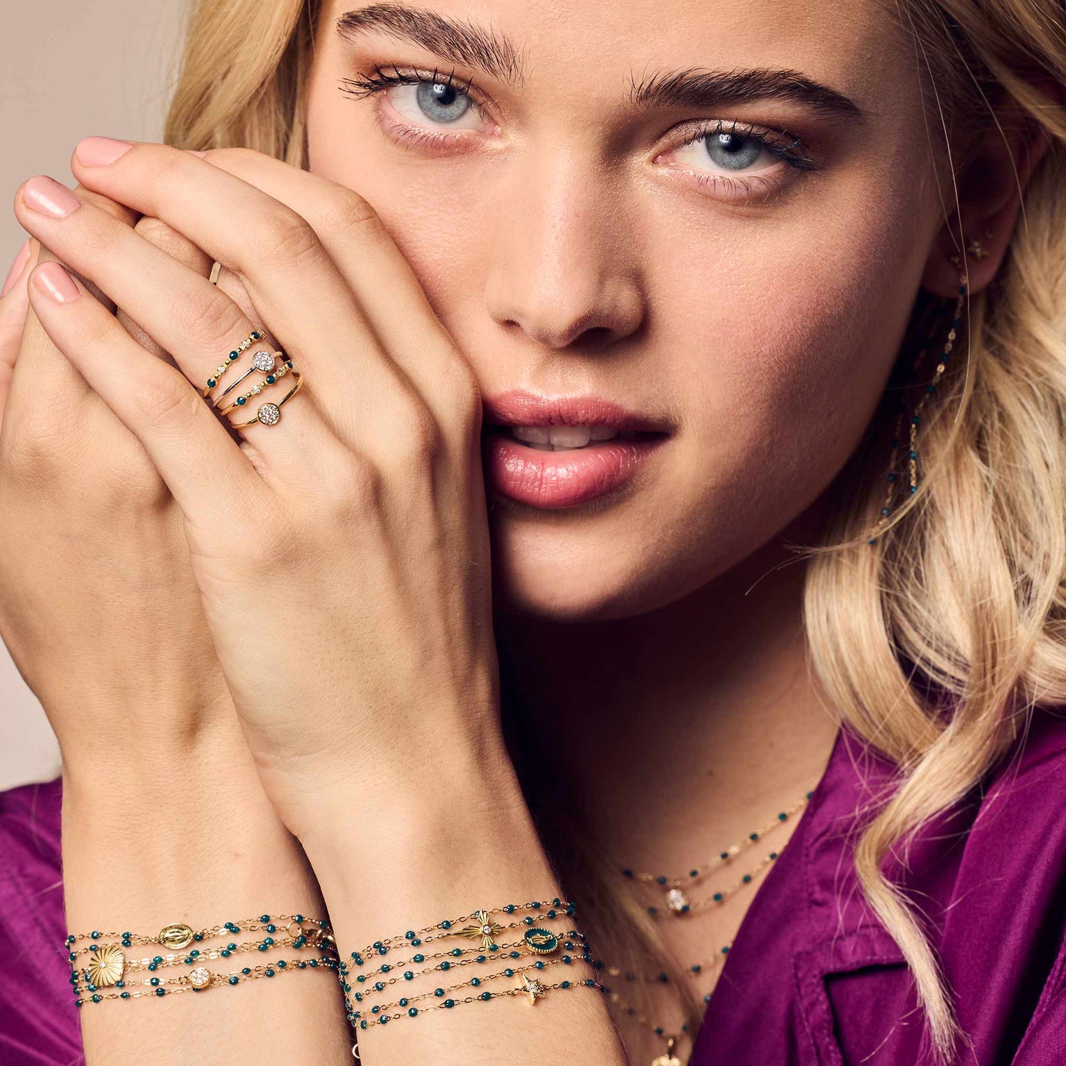 Visage d'une femme avec ses mains devant qui porte des bracelets gigi clozeau couleur jungle