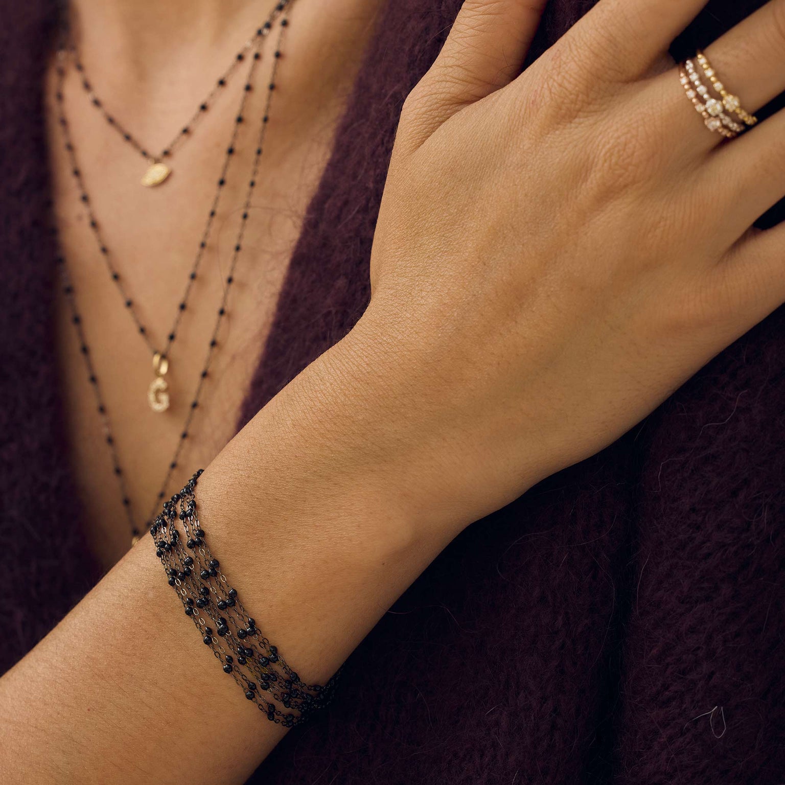 Poignet d’une femme portant différents bracelets de la nouvelle collection en or noir Gigi Clozeau.