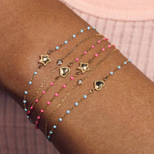 Photo du poignet d’une femme portant différents bracelets Gigi Clozeau.