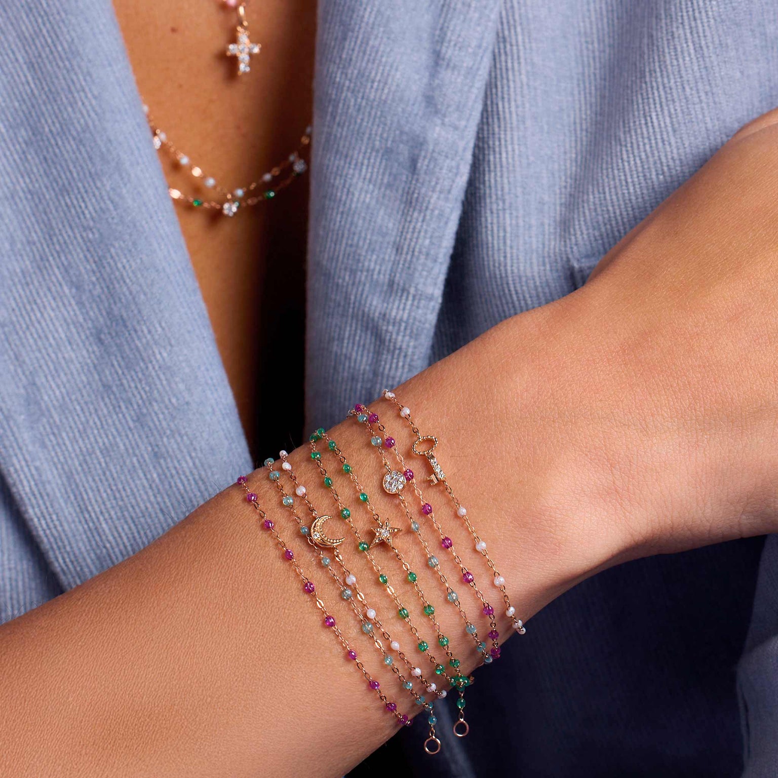 Photo du poignet d’une femme portant des bracelets Gigi Clozeau de différents modèles et couleurs.