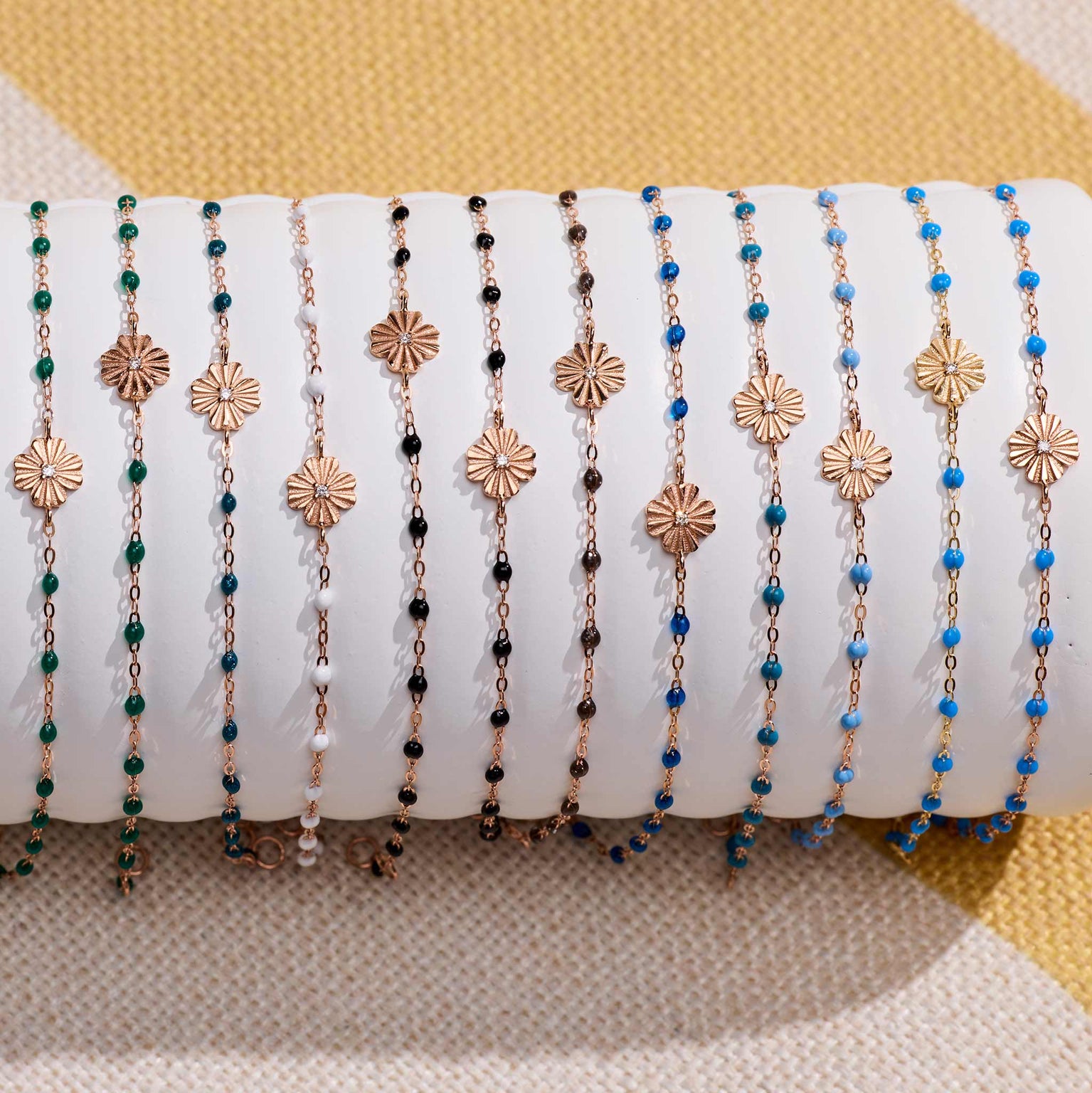 Photo de bracelet Trèfle Lumière Gigi Clozeau de différentes couleurs sur un oli 