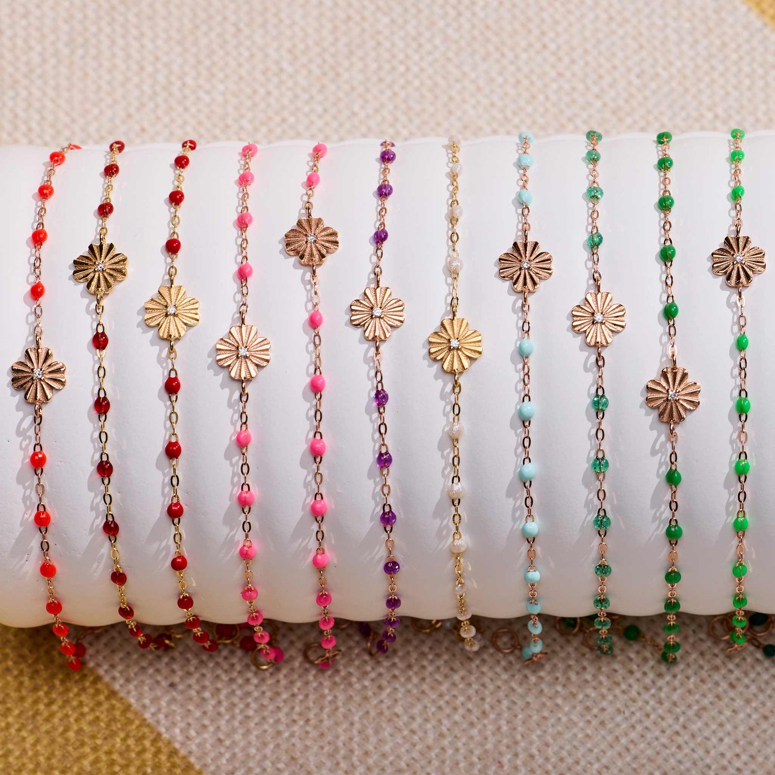 Photo de bracelet Trèfle Lumière Gigi Clozeau de différentes couleurs sur un oli 