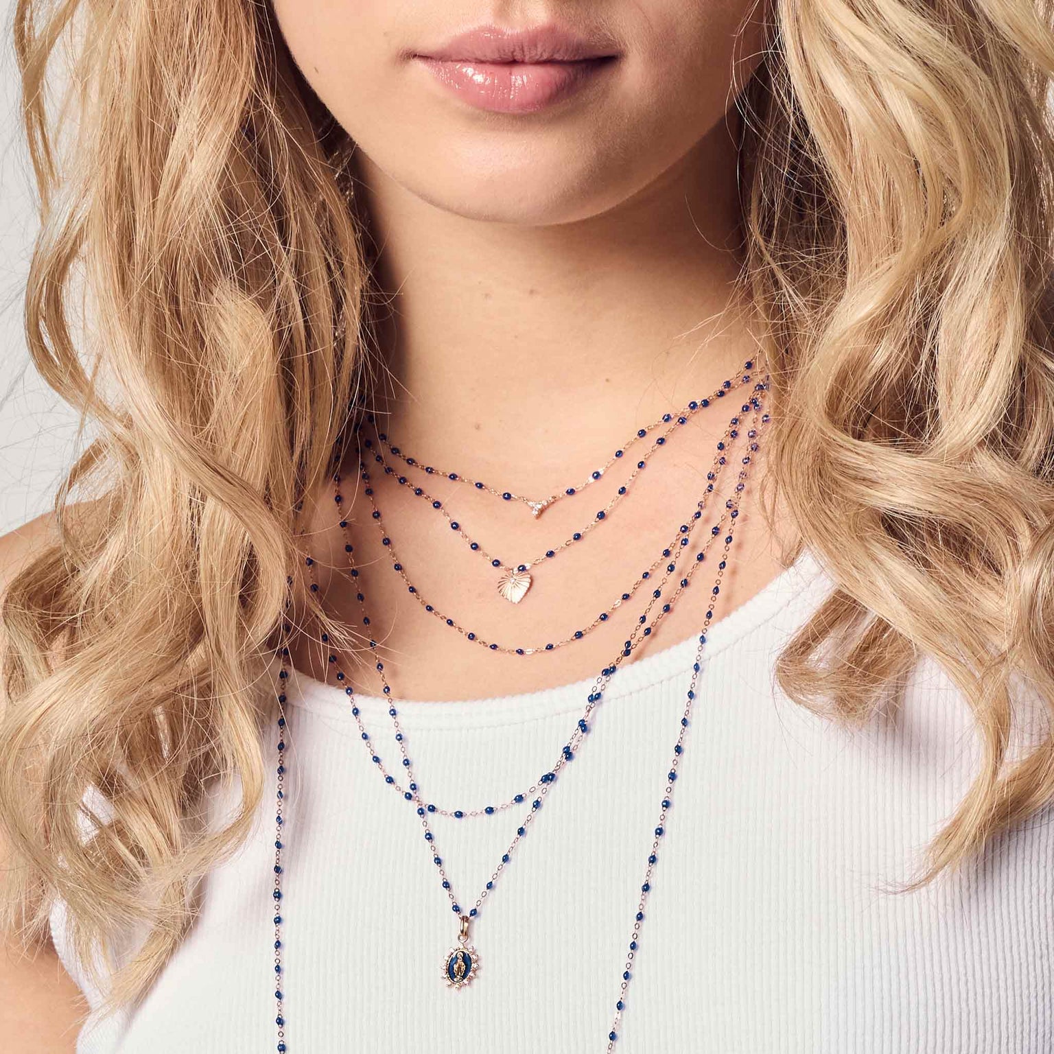 Photo du cou d'une femme portant des colliers Gigi Clozeau de couleur prusse 