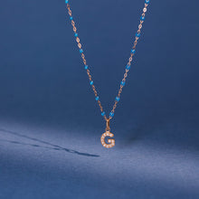 Photo de nature morte d'un pendentif Lucky Letters G Gigi Clozeau. 