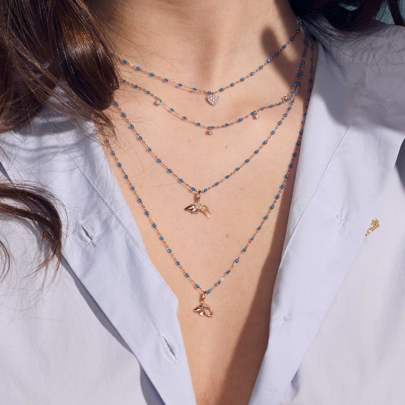 Photo du décolleté d’une femme portant des colliers Gigi Clozeau de la nouvelle couleur azur.