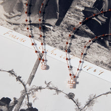 Photo de deux colliers Gigi Clozeau de couleur moka posé sur une photo.