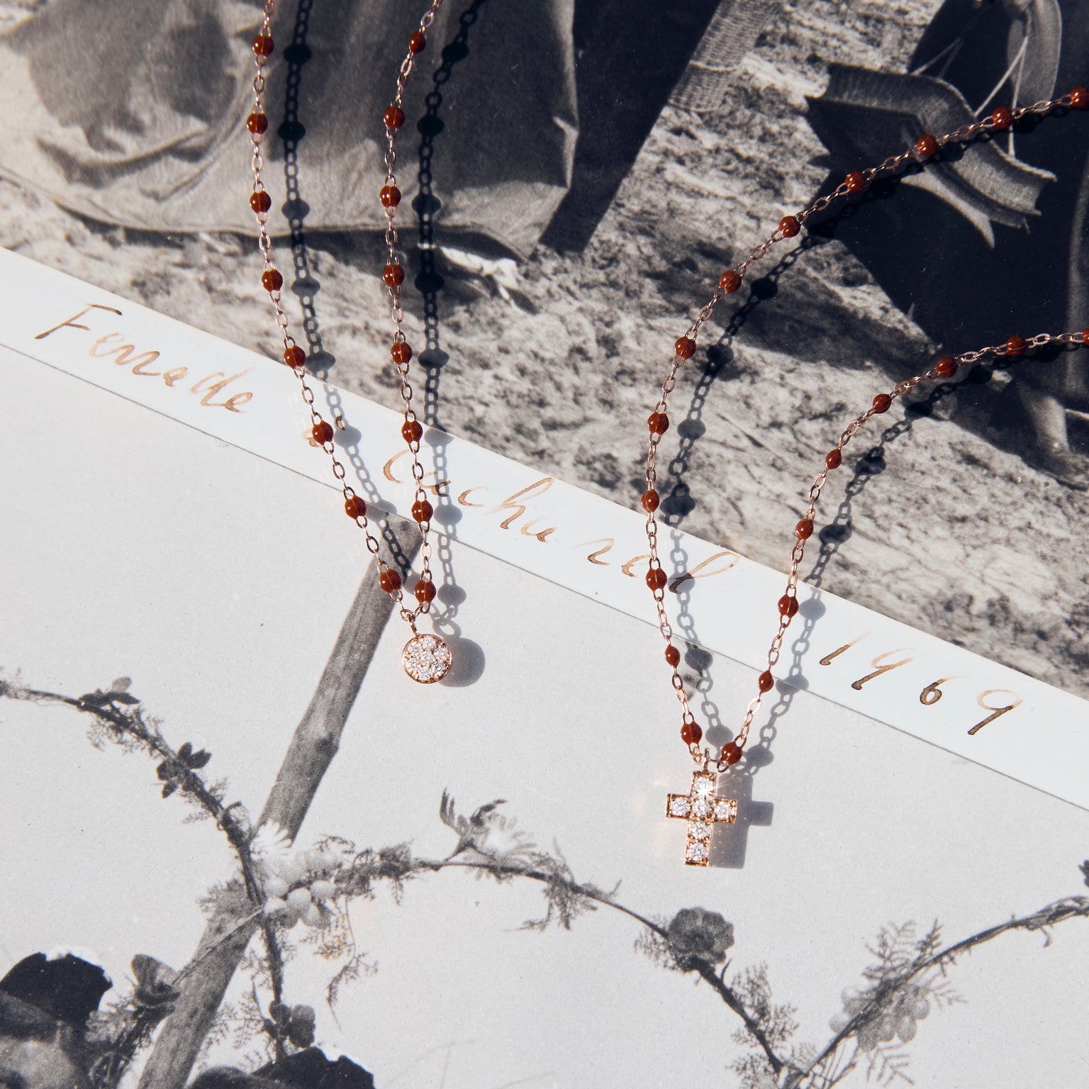 Photo de deux colliers Gigi Clozeau de couleur moka posé sur une photo.