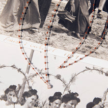 Photo de deux colliers Gigi Clozeau de couleur moka posé sur une photo.