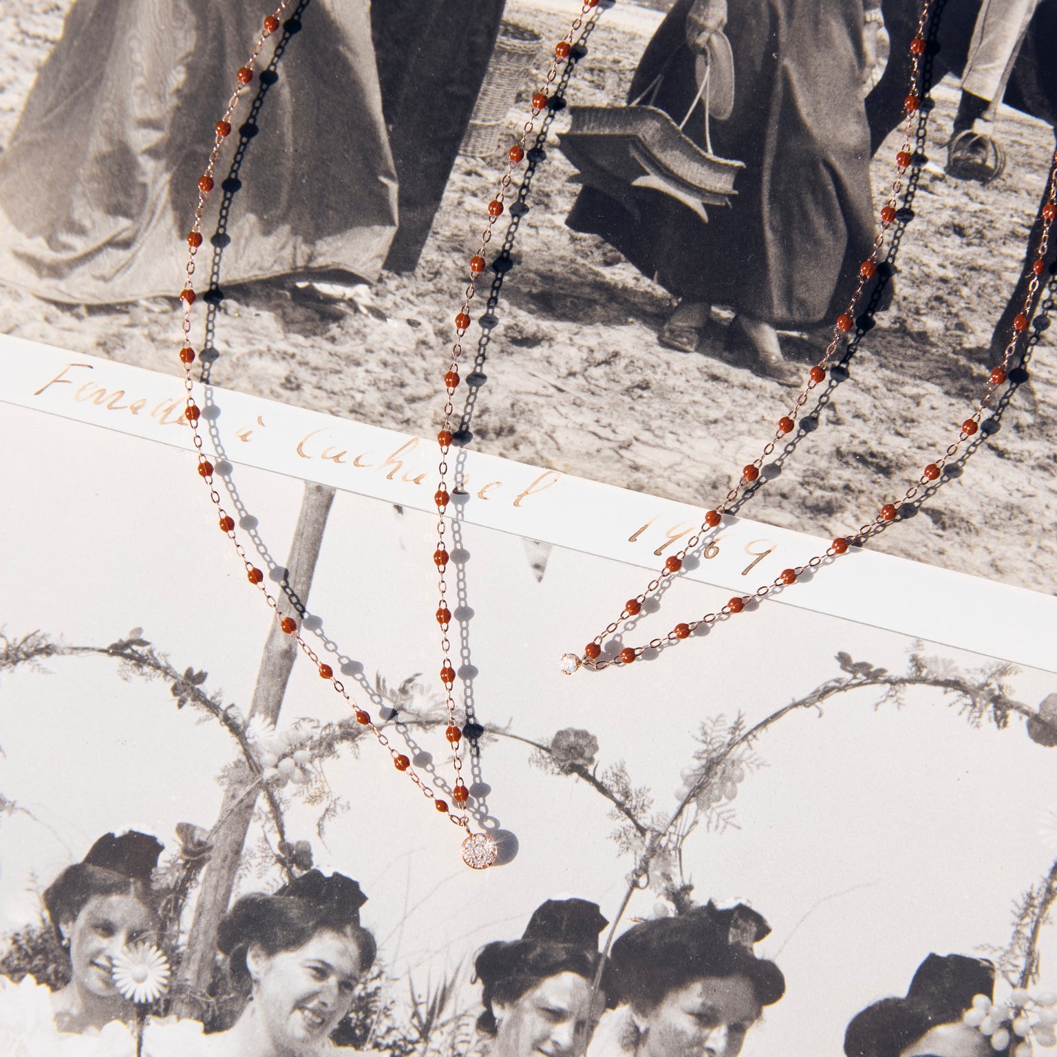 Photo de deux colliers Gigi Clozeau de couleur moka posé sur une photo.