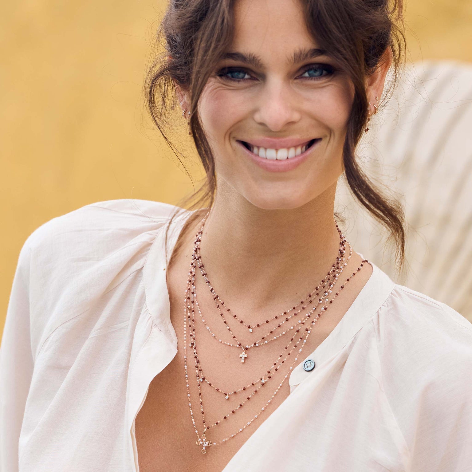 Photo du cou d’une femme portant des colliers Gigi Clozeau de couleurs opale et moka.