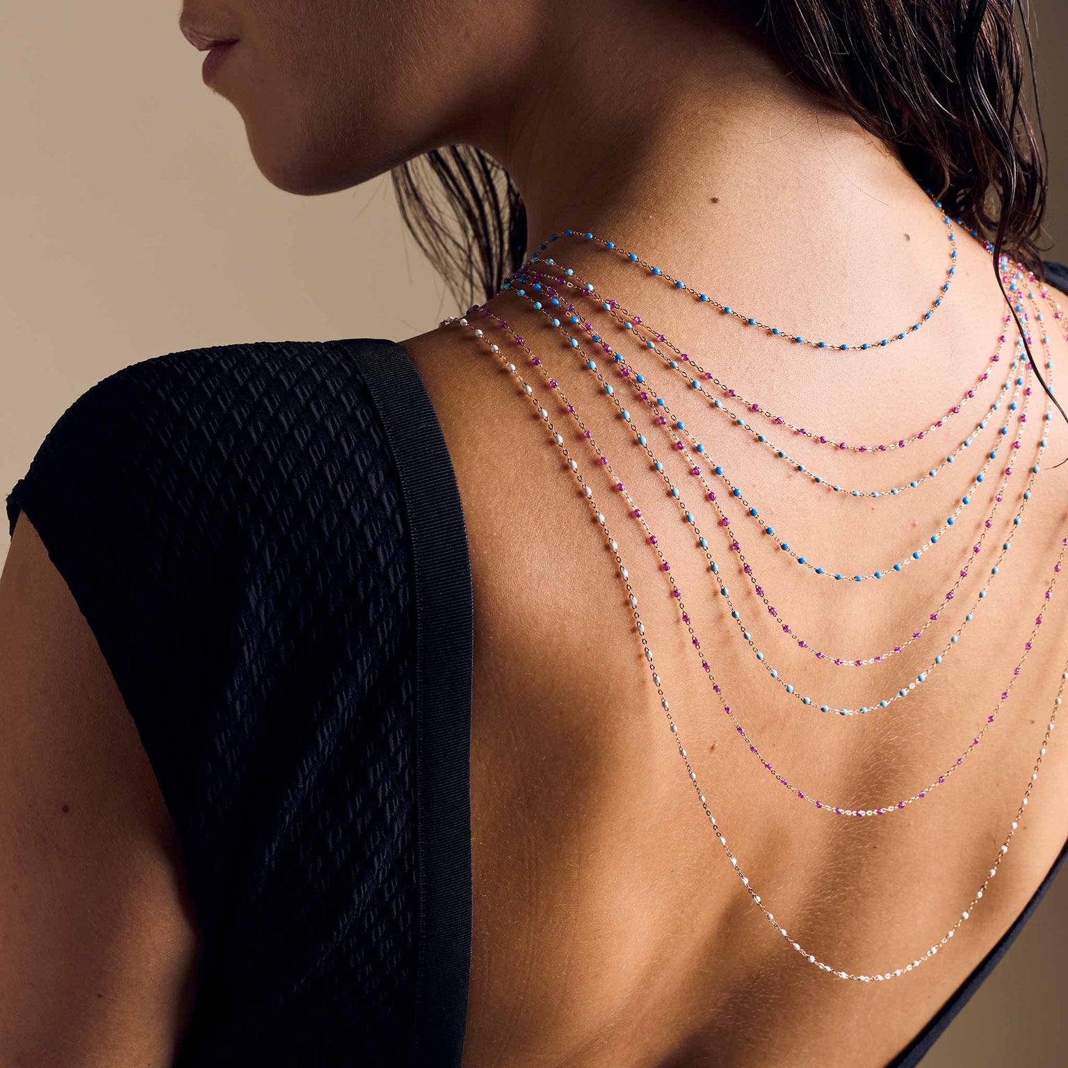 Photo du dos d'une femme avec des colliers Gigi Clozeau suspendus 