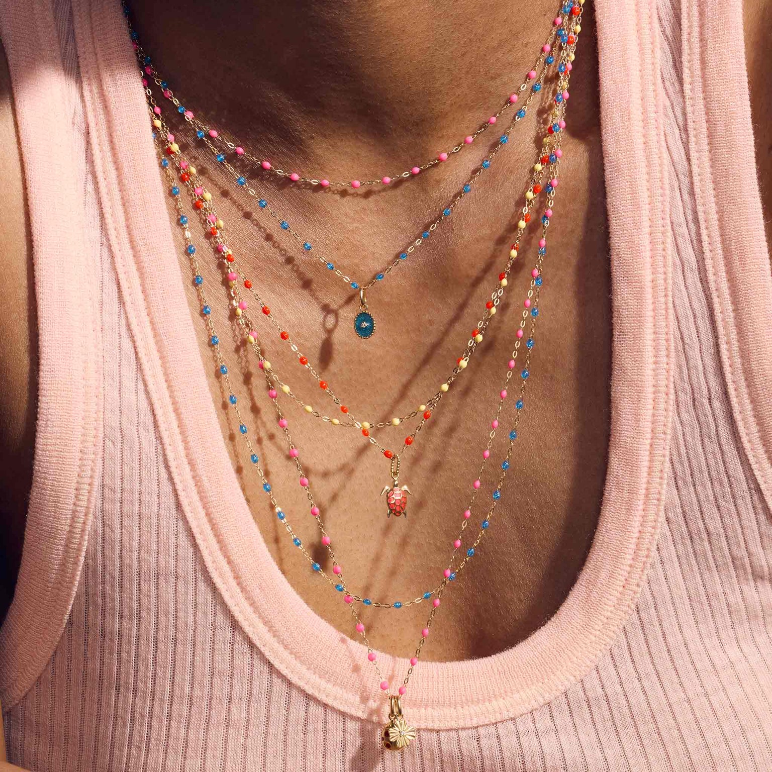 Photo du décolleté d’une femme portant différents colliers colorés Gigi Clozeau.
